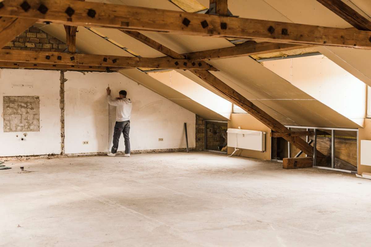 Man measuring wall on construction site