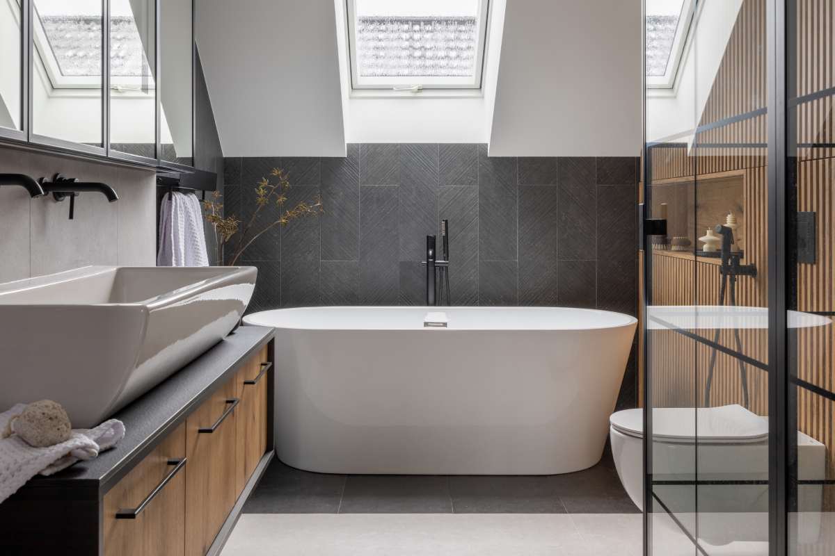 Stylish interior of bathroom with bathtub, shower, towels and other personal bathroom accessories. Modern and design interior concept. Roof window. Template.